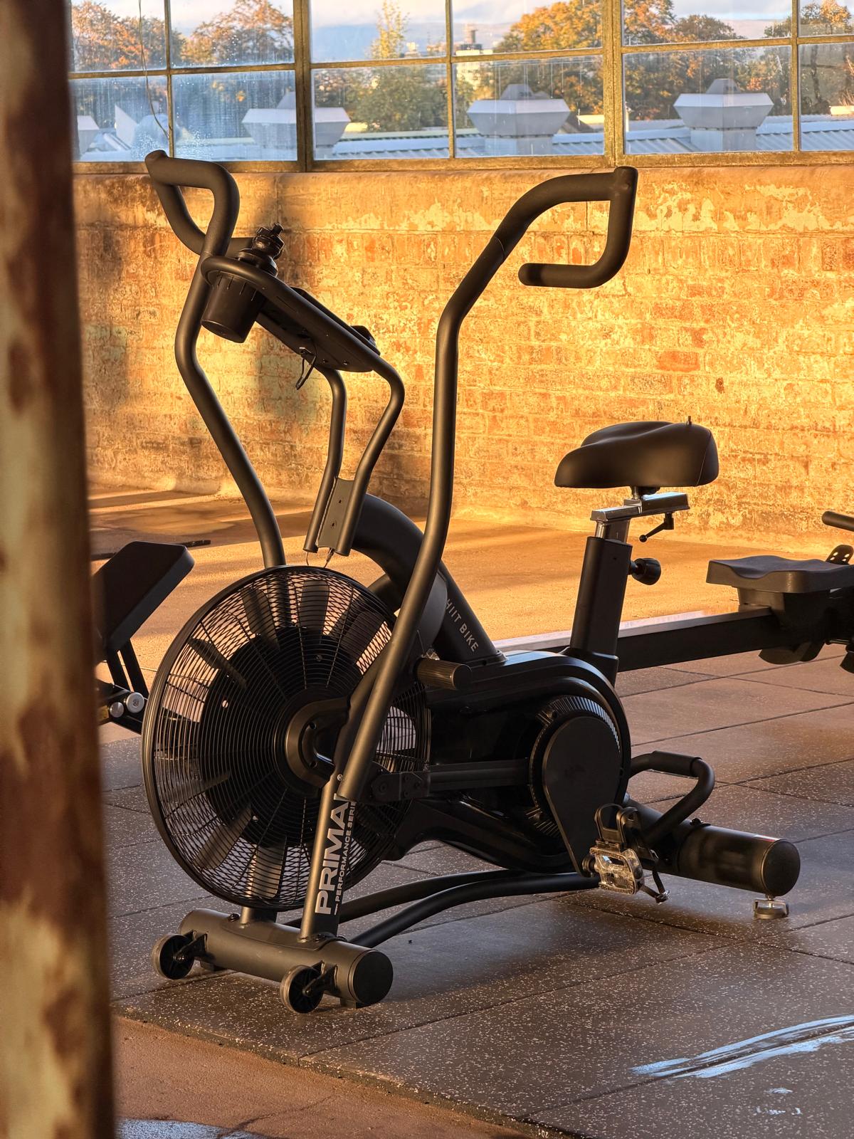 Exercise bike in warm window light in front of exposed brick